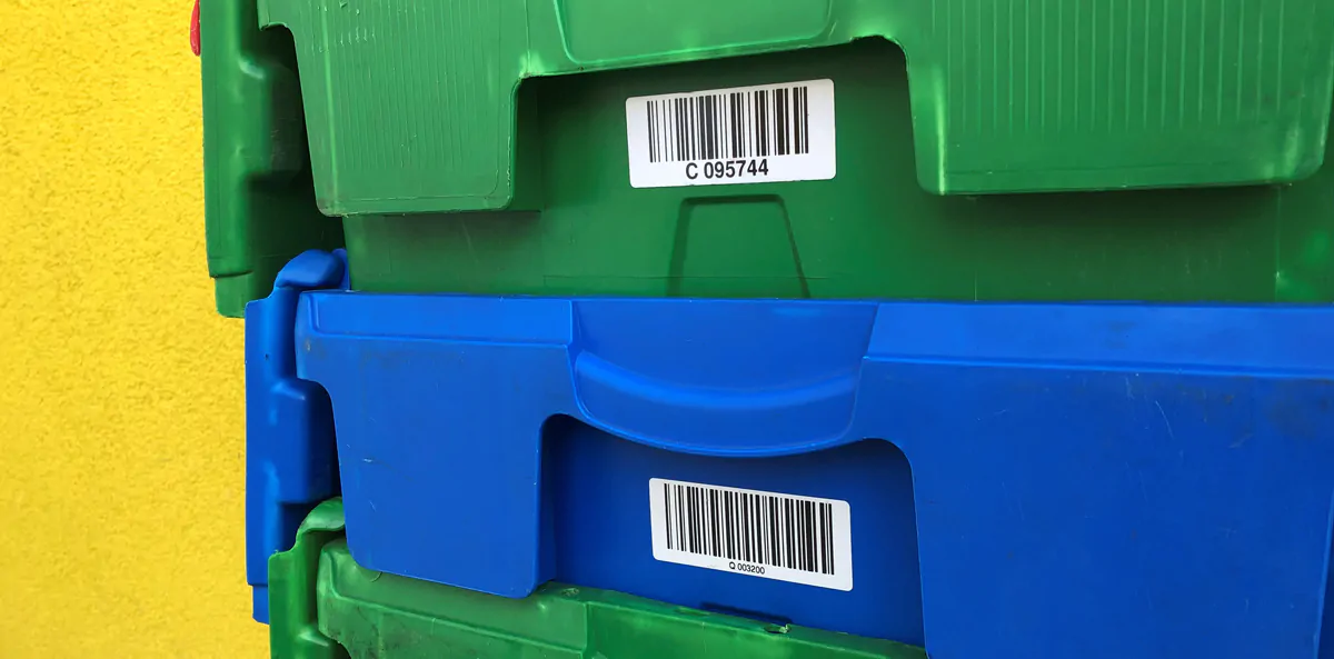 Sporing af emballage. Mærkning af returemballage med etiketter. På billedet ses plastkasser med stregkode etiketter.
